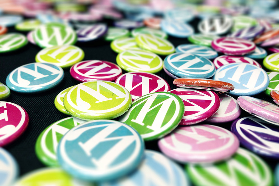 A pile of colorful WordPress branded buttons on a swag table
