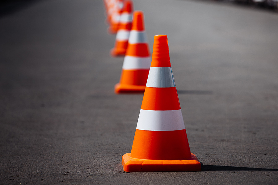 A line of orange construction cones to indicate potential danger