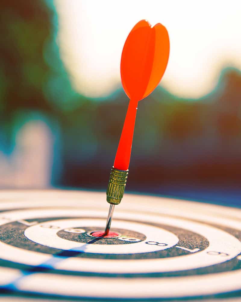 A red dart stuck in the center of a bullseye because the right website copy and business blogging can attract the perfect clients