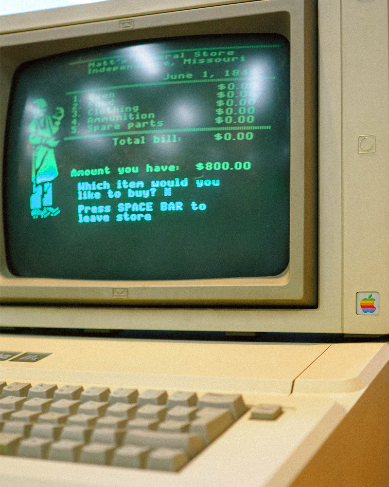 Vintage apple computer with the Oregon Trail game on the screen