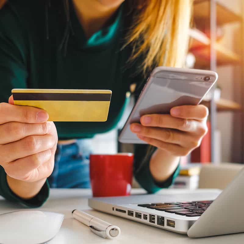 A customer holding a credit card and making a buying decision because the copy on the website they're browsing resonated with them